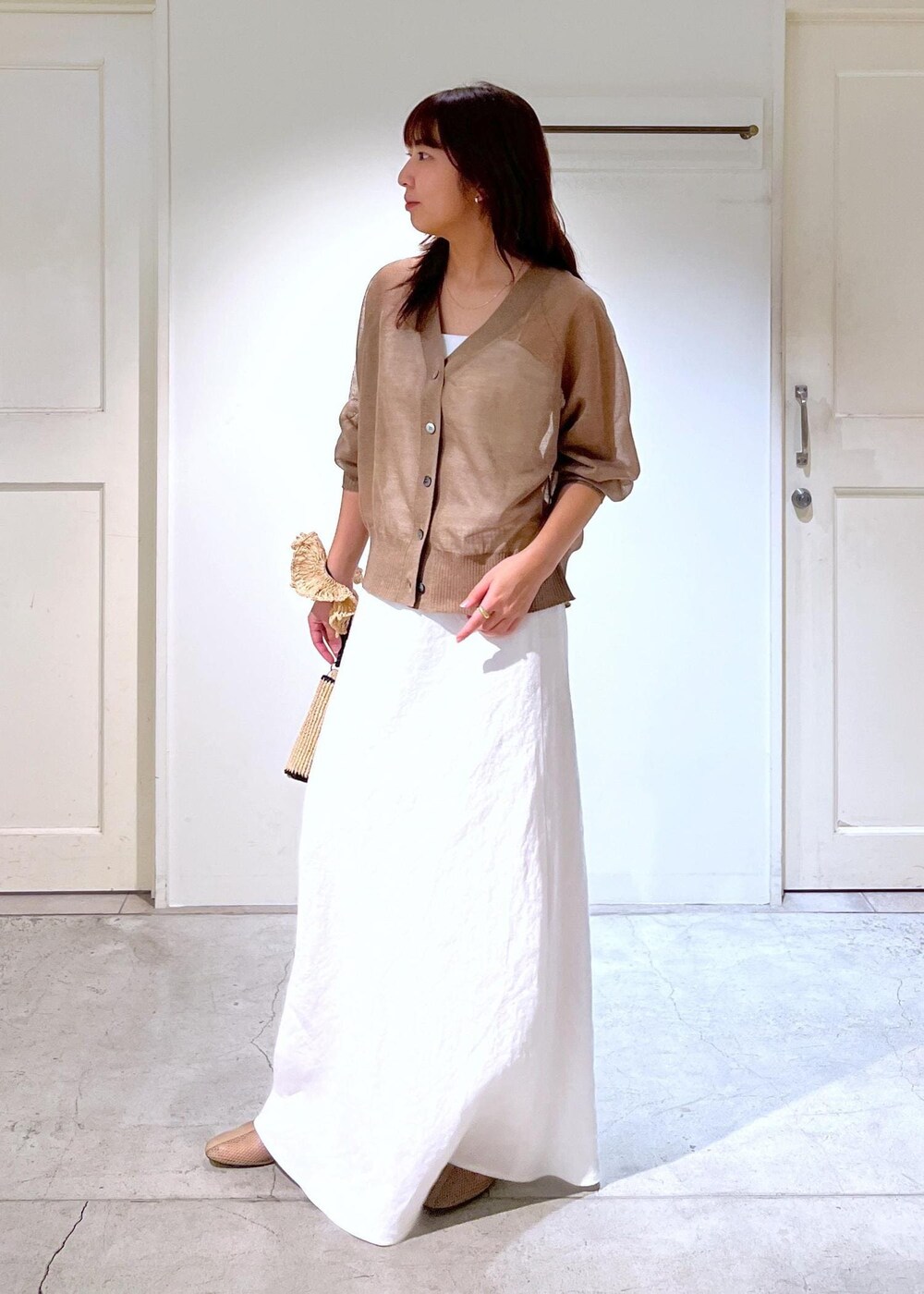 ベージュ系のパンプス、ホワイト系のスカート、ホワイト系のキャミソールを着用したレディースの春コーディネートの3枚目の写真