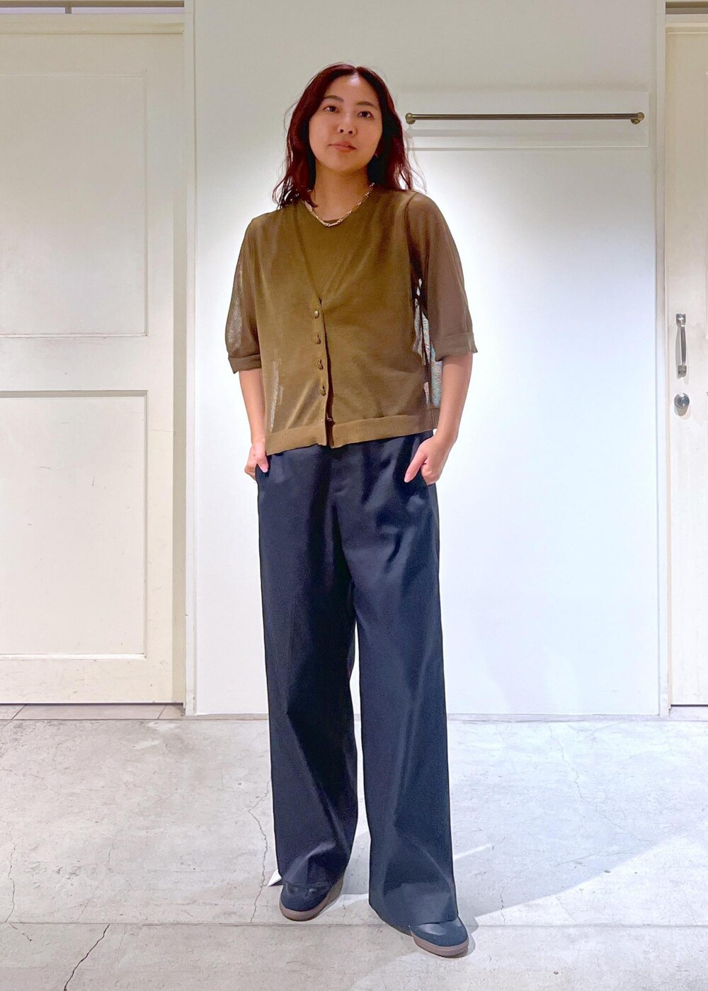 ブラック系のその他パンツ、ホワイト系のハンドバッグ、グリーン系のタンクトップを着用したレディースの夏コーディネートの4枚目の写真