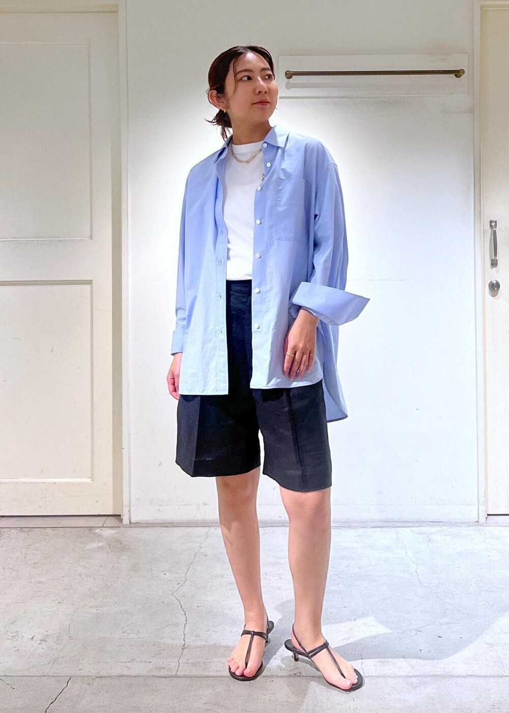 ブラック系のサンダル、ホワイト系のTシャツ/カットソー、ベージュ系のかごバッグを着用したレディースの春コーディネートの3枚目の写真