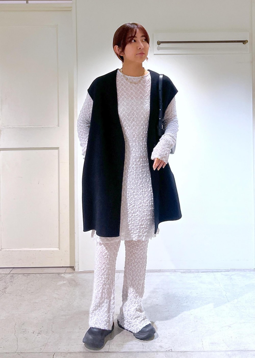 グレー系のワンピース、ブラック系のベスト、グレー系のその他パンツを着用したレディースの秋コーディネートの2枚目の写真