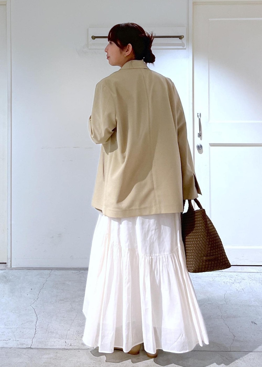 ベージュ系のパンプス、ベージュ系のテーラードジャケット、ホワイト系のスカートを着用したレディースの春コーディネートの3枚目の写真