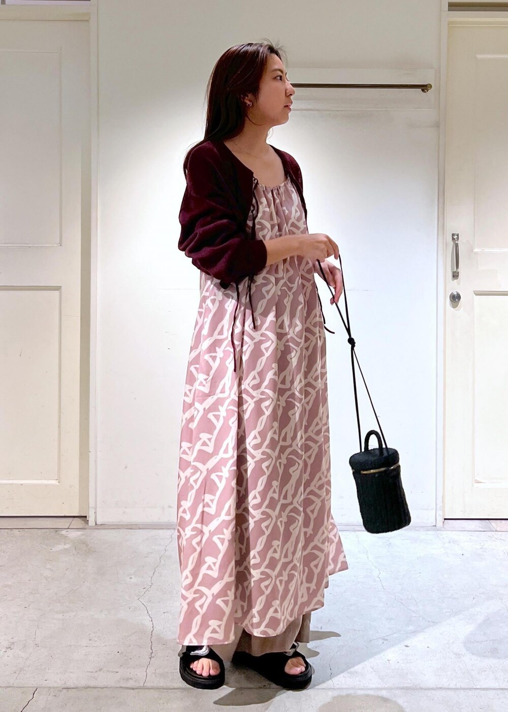 イエロー系のワンピース、レッド系のニット/セーター、イエロー系のその他パンツを着用したレディースの春コーディネートの3枚目の写真