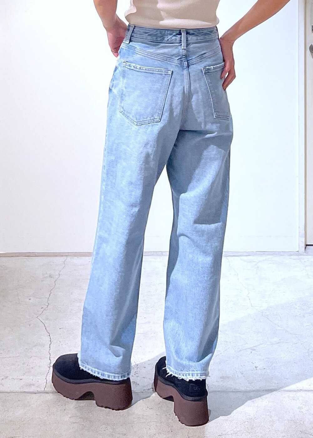 ブラック系のブーツ、ホワイト系のタンクトップ、ブラック系のハンドバッグを着用したレディースの冬コーディネートの5枚目の写真