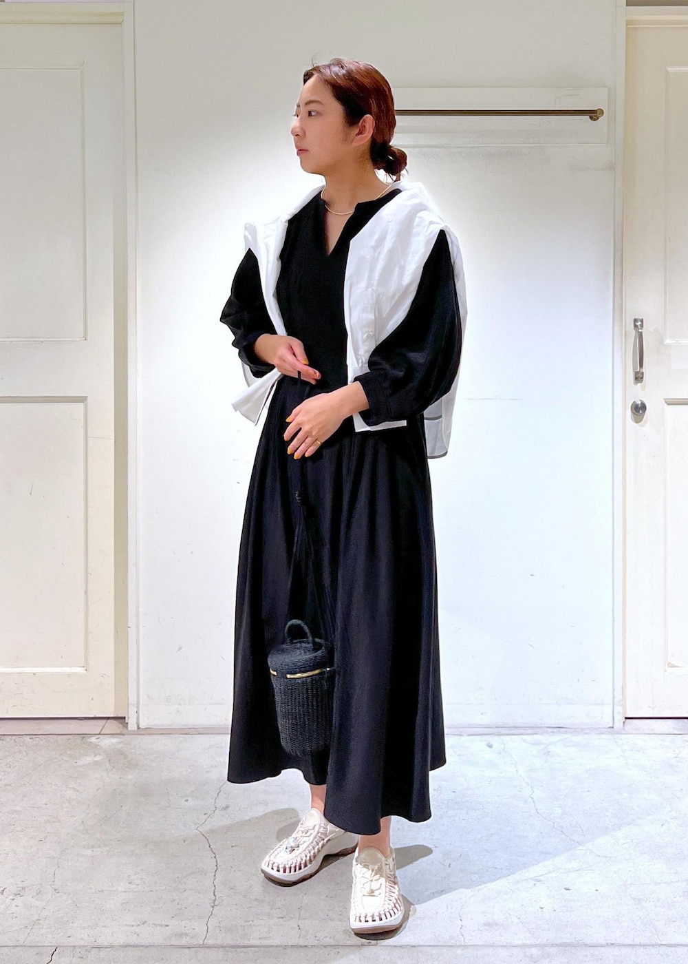 ホワイト系のサンダル、ブラック系のショルダーバッグ、ブラック系のワンピースを着用したレディースの春コーディネートの2枚目の写真