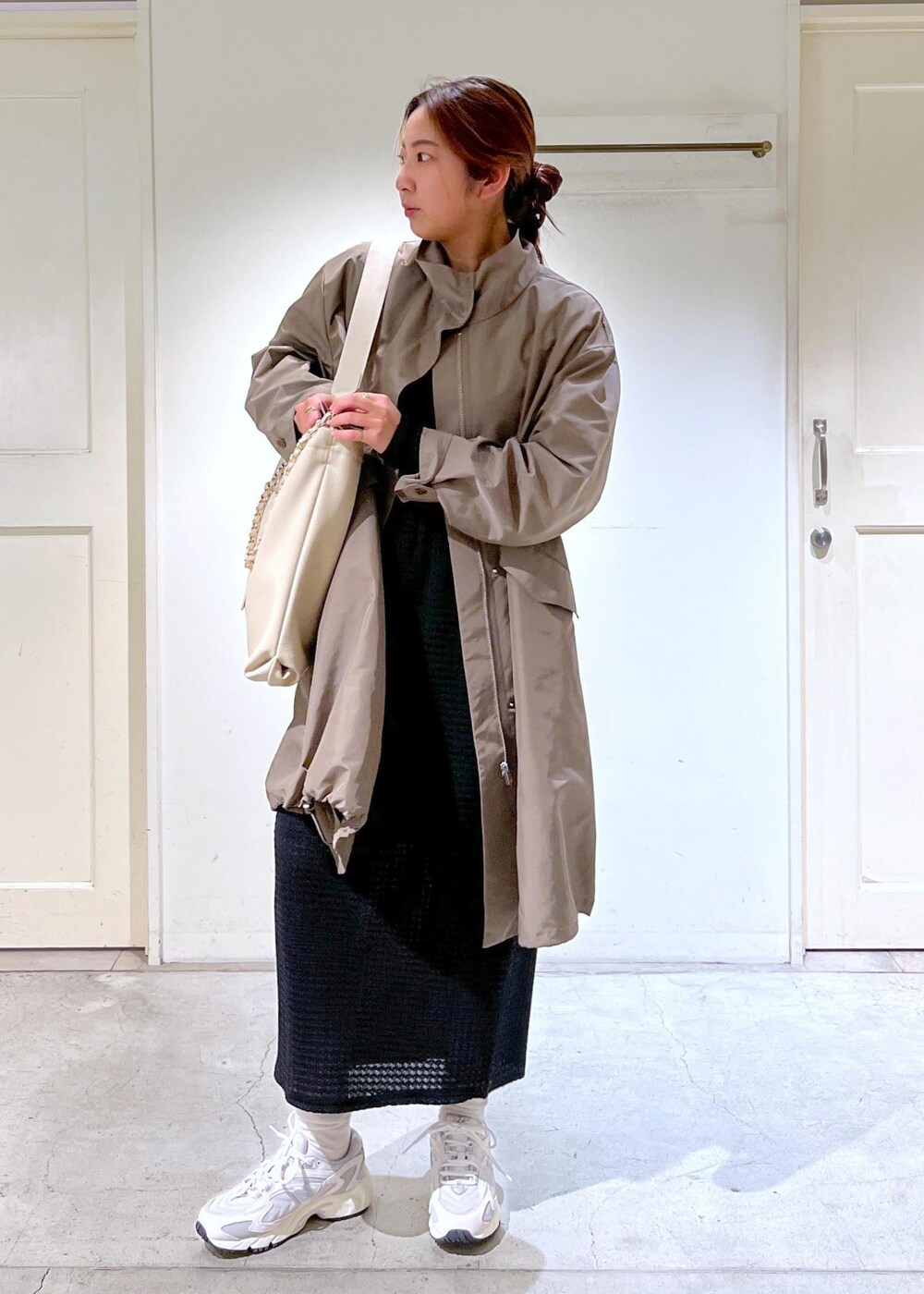 ホワイト系のスニーカー、ブラック系のスカート、ブラウン系のミリタリージャケットを着用したレディースの春コーディネートの3枚目の写真