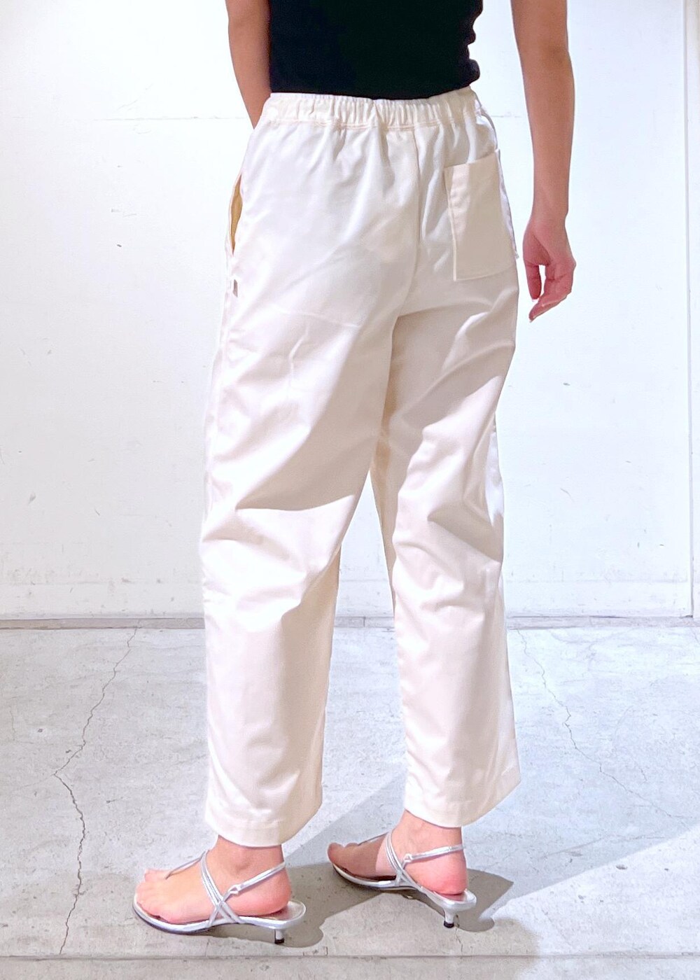 ブラック系のチューブトップ、シルバー系のサンダル、ブラック系のTシャツ/カットソーを着用したレディースの春コーディネートの6枚目の写真