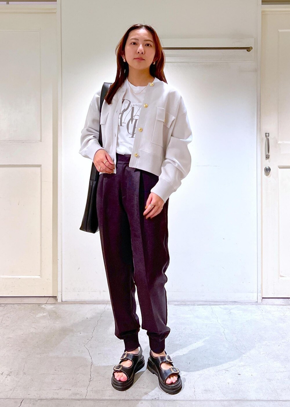 グレー系のその他パンツ、ブラック系のショルダーバッグ、ホワイト系のTシャツ/カットソーを着用したレディースの春コーディネートの2枚目の写真