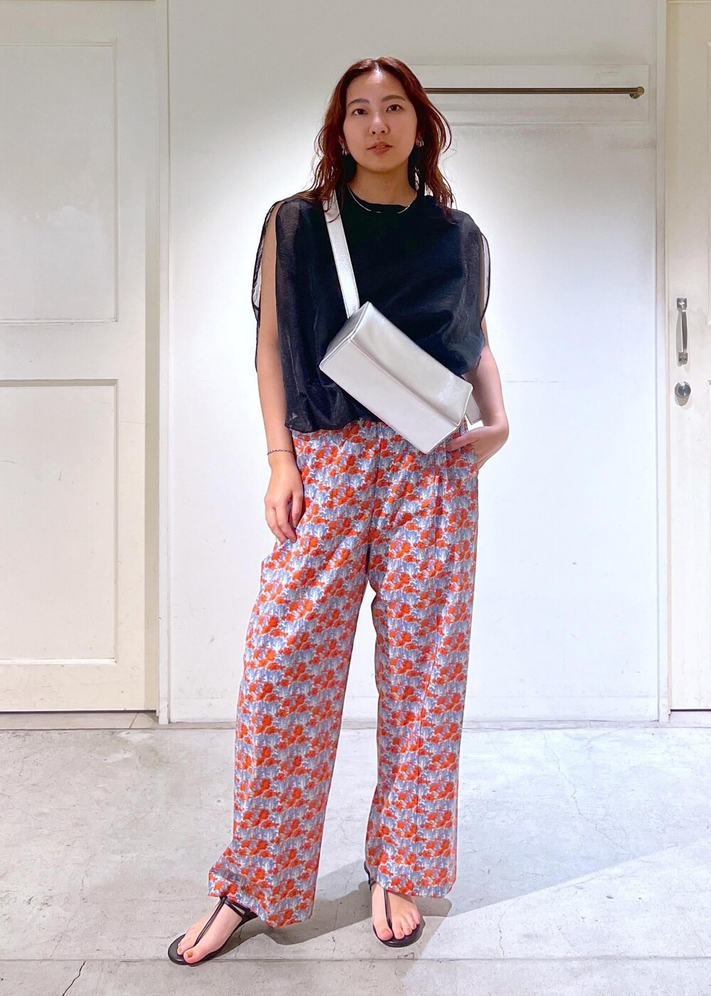 シルバー系のショルダーバッグ、ブラック系のサンダル、ブラック系のTシャツ/カットソーを着用したレディースの夏コーディネートの6枚目の写真