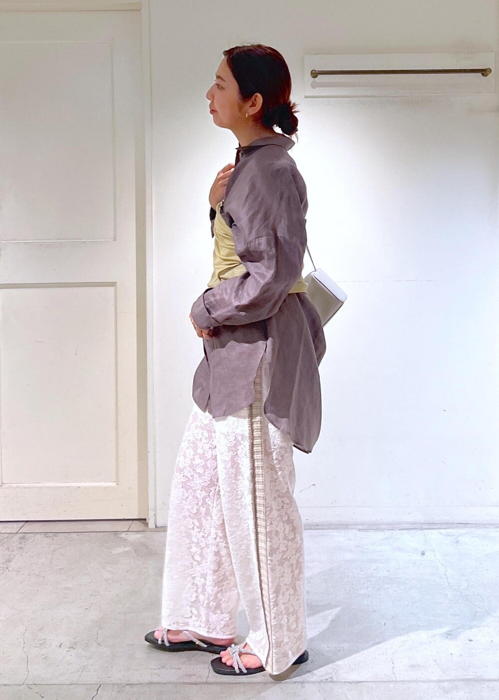 シルバー系のサンダル、ホワイト系のタンクトップ、イエロー系のキャミソールを着用したレディースの夏コーディネートの5枚目の写真