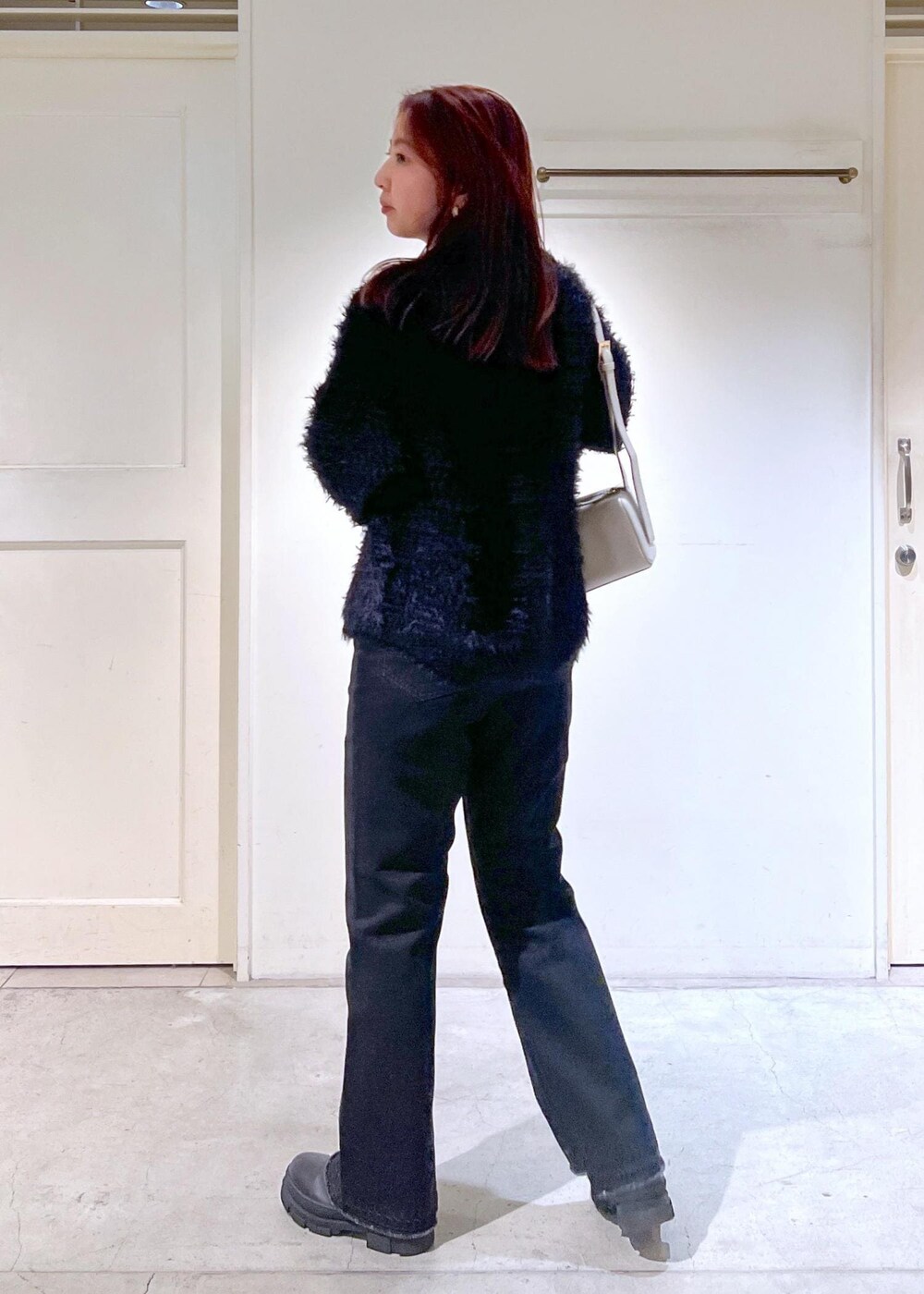 ブラック系のブーツ、ブラック系のTシャツ/カットソー、グレー系のデニムパンツを着用したレディースの秋コーディネートの5枚目の写真