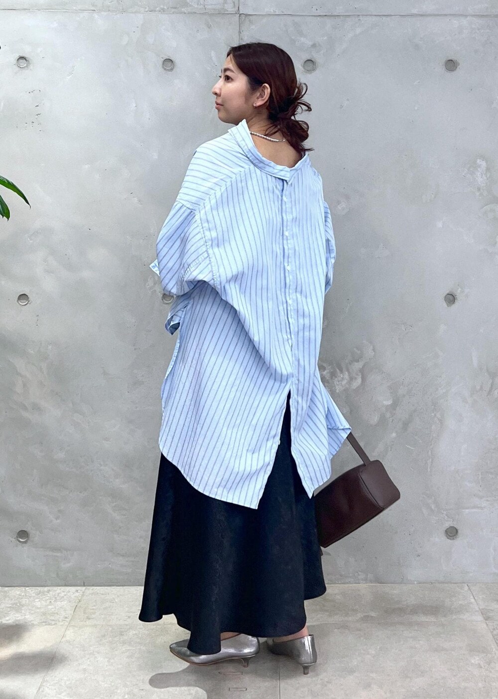 ブルー系のシャツ/ブラウス、ブラック系のスカート、ブラウン系のショルダーバッグを着用したレディースの夏コーディネートの3枚目の写真