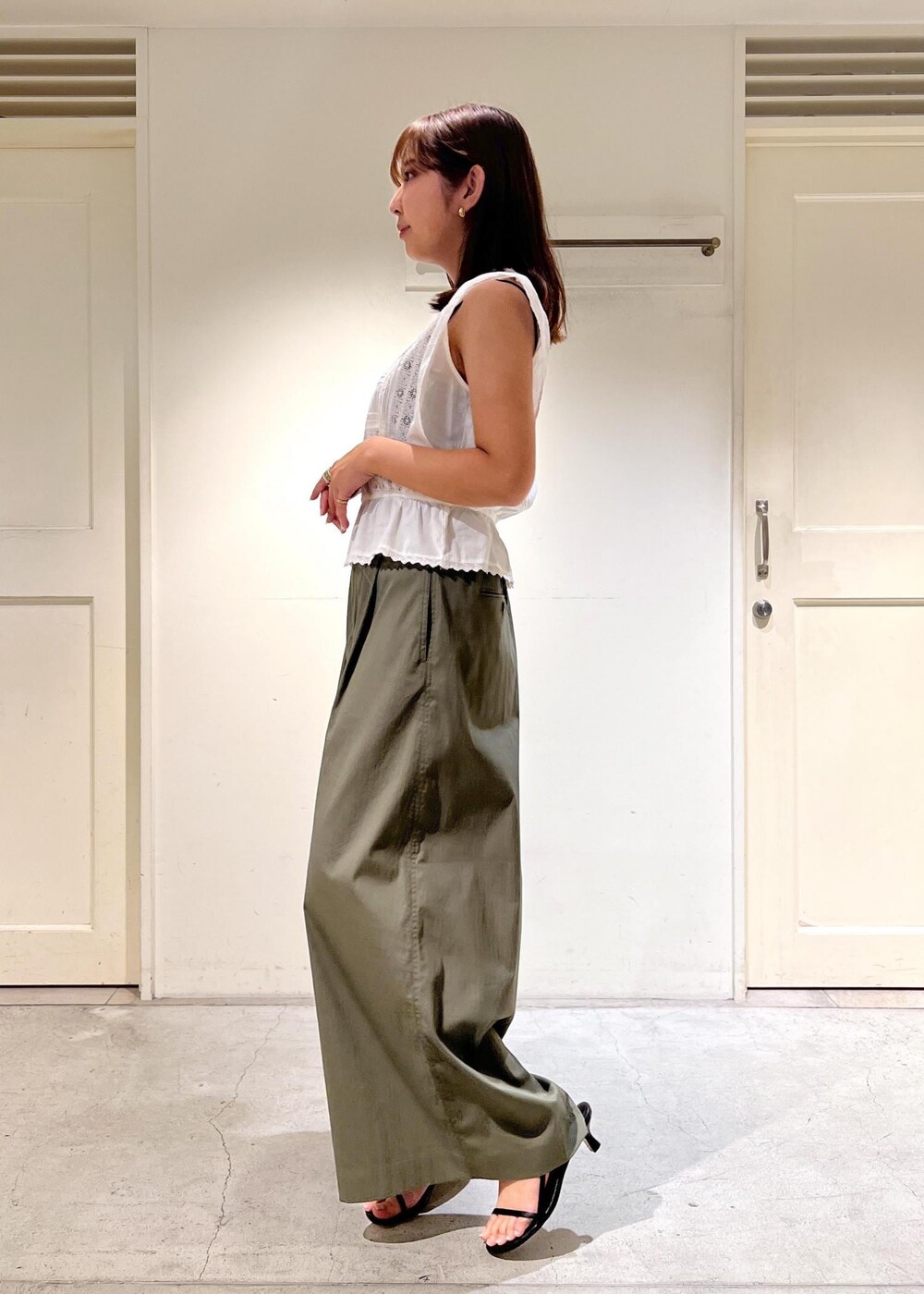 ブラック系のサンダル、グリーン系のその他パンツ、ホワイト系のシャツ/ブラウスを着用したレディースの夏コーディネートの2枚目の写真