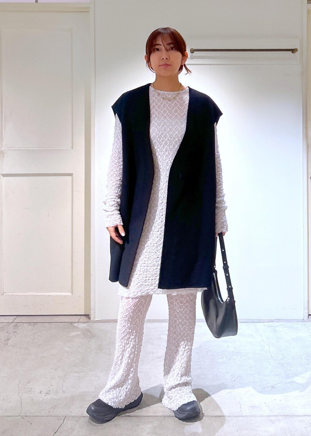 グレー系のワンピース、ブラック系のベスト、グレー系のその他パンツを着用したレディースの秋コーディネートの4枚目の写真