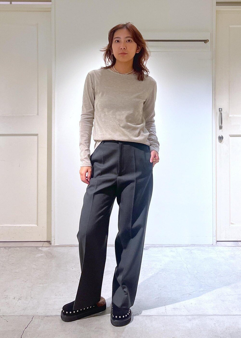 ブラック系のショルダーバッグ、グレー系のスラックス、ゴールド系のTシャツ/カットソーを着用したレディースの秋コーディネートの5枚目の写真