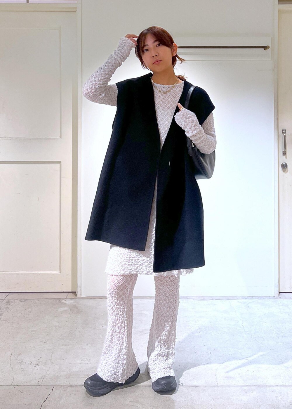 グレー系のワンピース、ブラック系のベスト、グレー系のその他パンツを着用したレディースの秋コーディネートの3枚目の写真