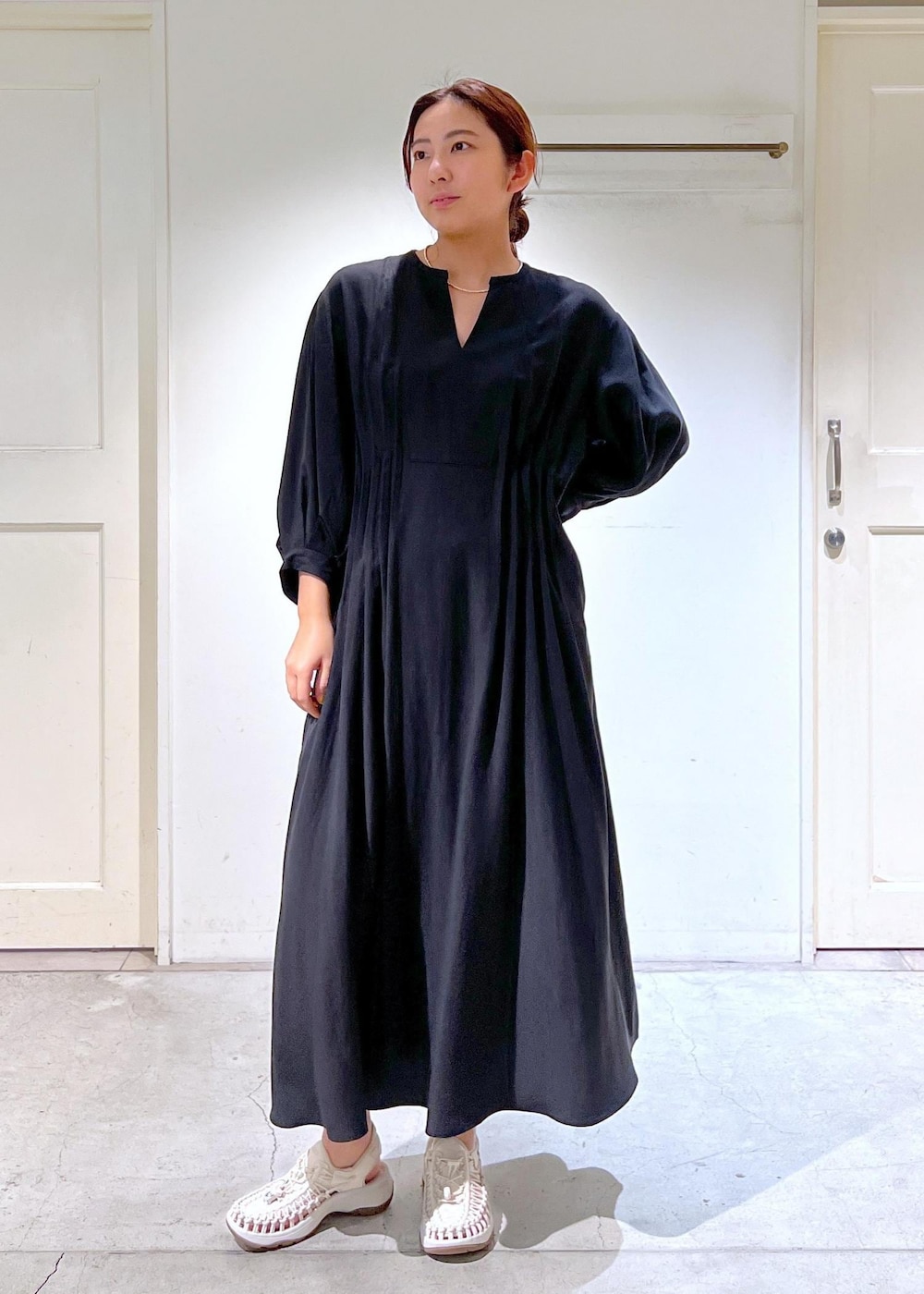 ホワイト系のサンダル、ブラック系のショルダーバッグ、ブラック系のワンピースを着用したレディースの春コーディネートの4枚目の写真