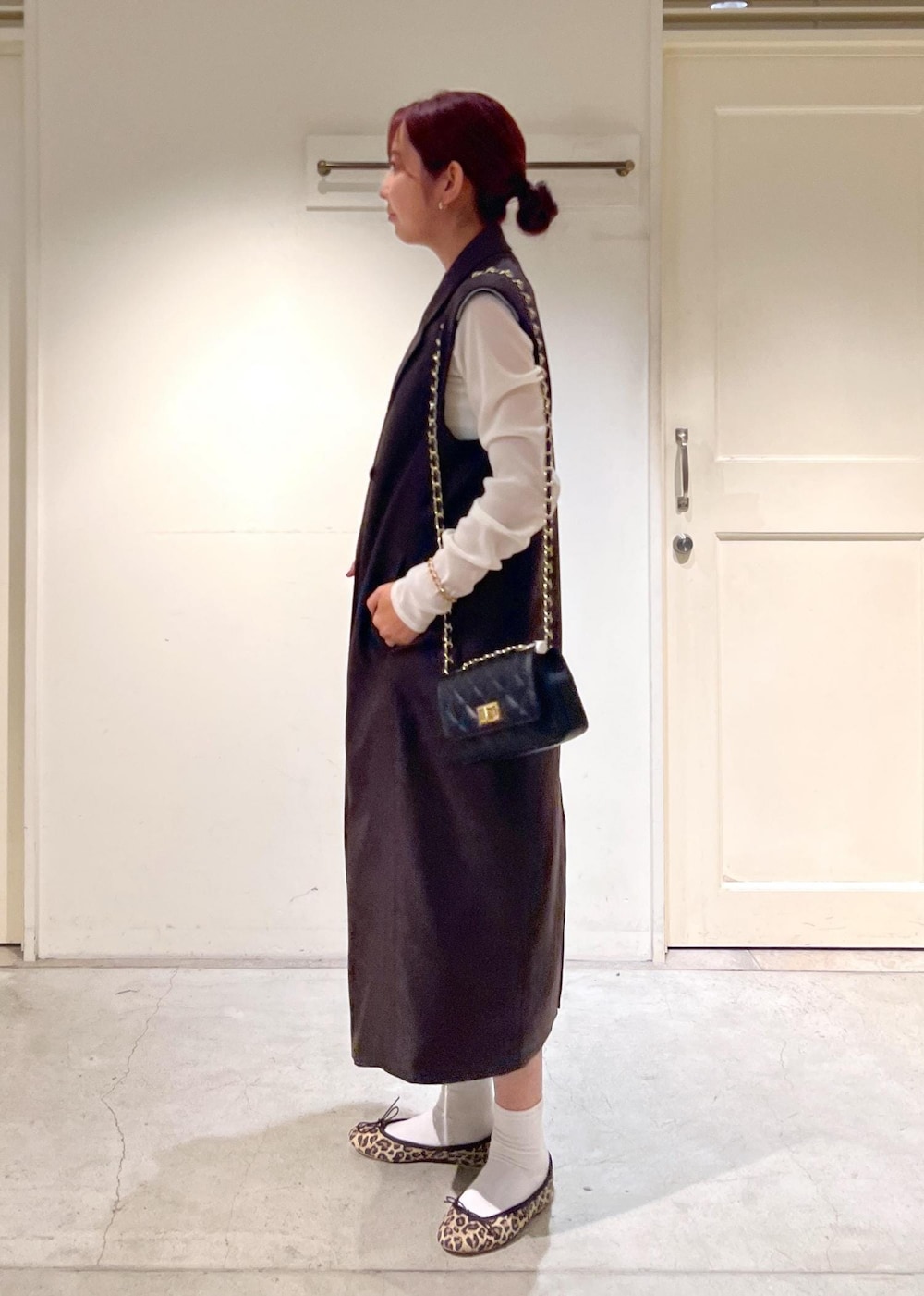 ブラック系のショルダーバッグ、ブラウン系のジャンパースカート、ブラウン系のバレエシューズを着用したレディースの秋コーディネートの3枚目の写真