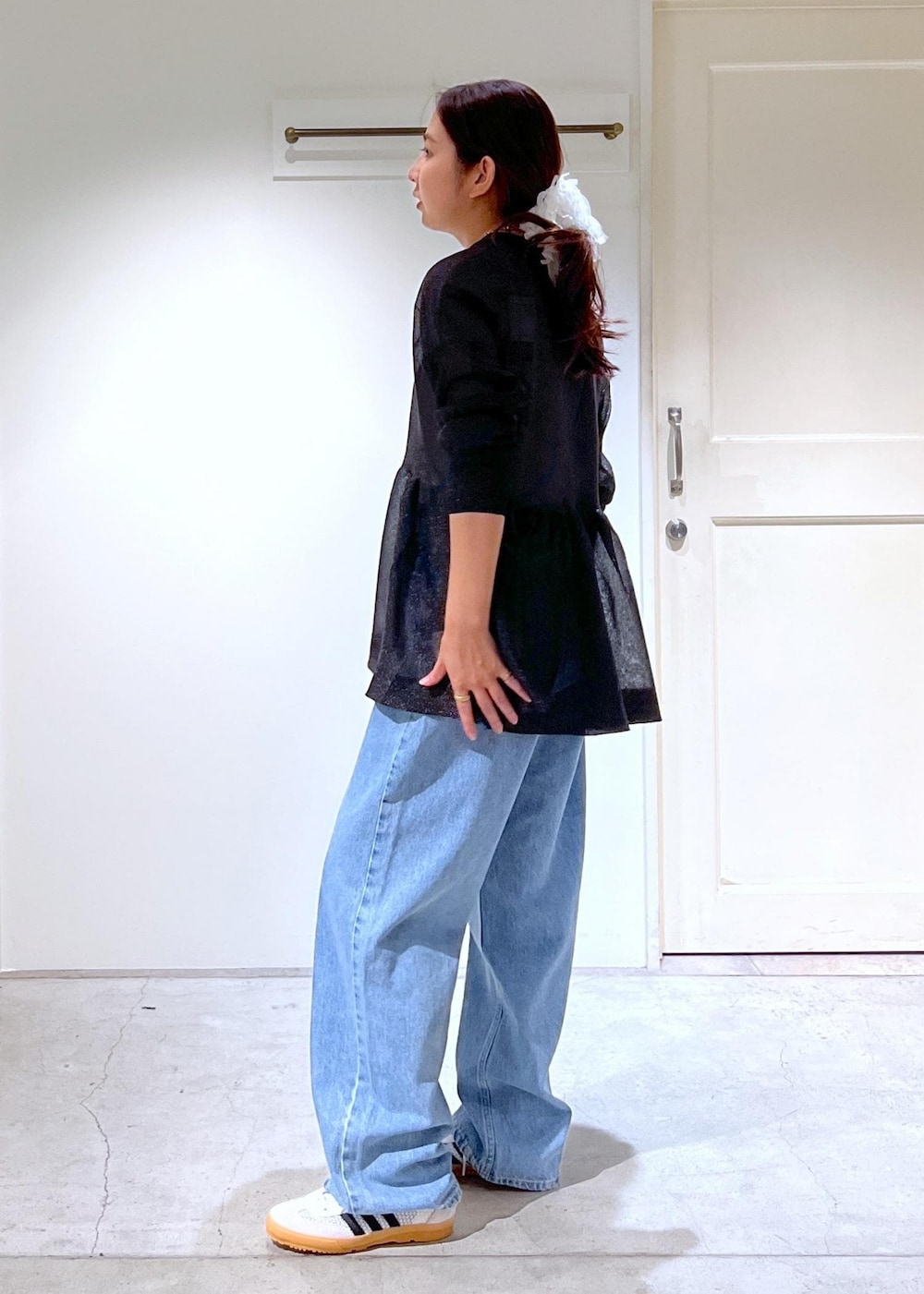 ブラック系のハンドバッグ、ブルー系のデニムパンツ、ブラック系のカーディガン/ボレロを着用したレディースの夏コーディネートの3枚目の写真