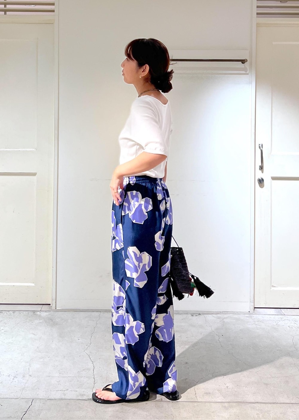 ブラック系のサンダル、ホワイト系のTシャツ/カットソー、ブラック系のハンドバッグを着用したレディースの夏コーディネートの3枚目の写真