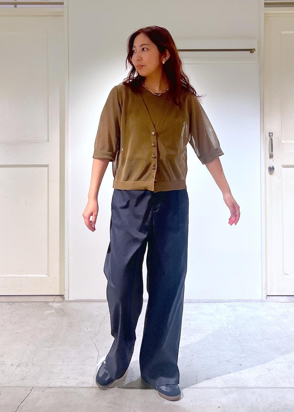 ブラック系のその他パンツ、ホワイト系のハンドバッグ、グリーン系のタンクトップを着用したレディースの夏コーディネートの5枚目の写真