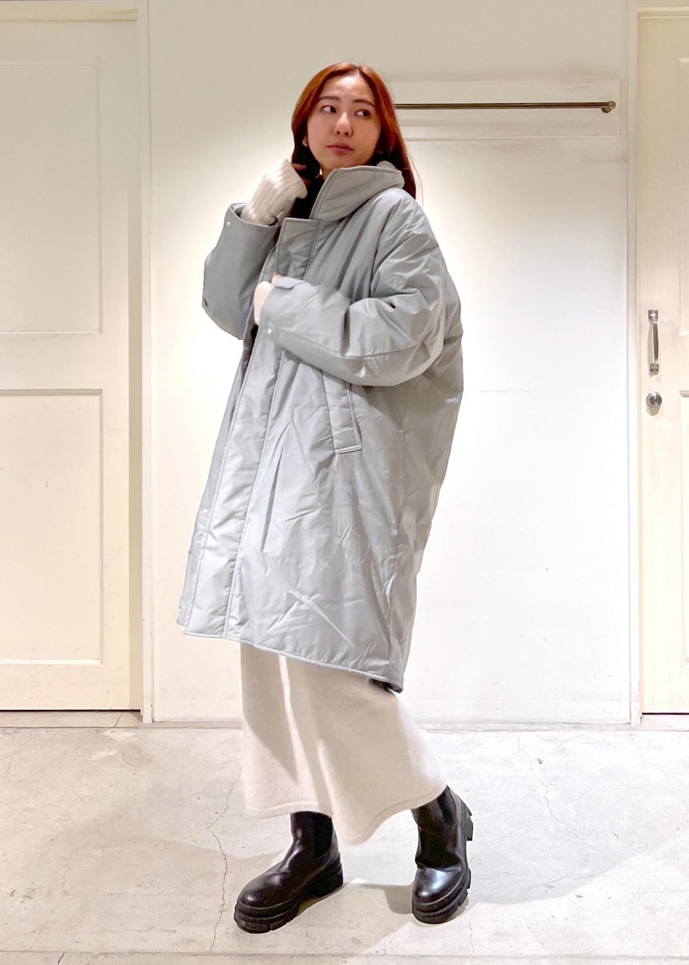 ホワイト系のスウェット、シルバー系のその他アウター、ホワイト系のスカートを着用したレディースの冬コーディネートの2枚目の写真