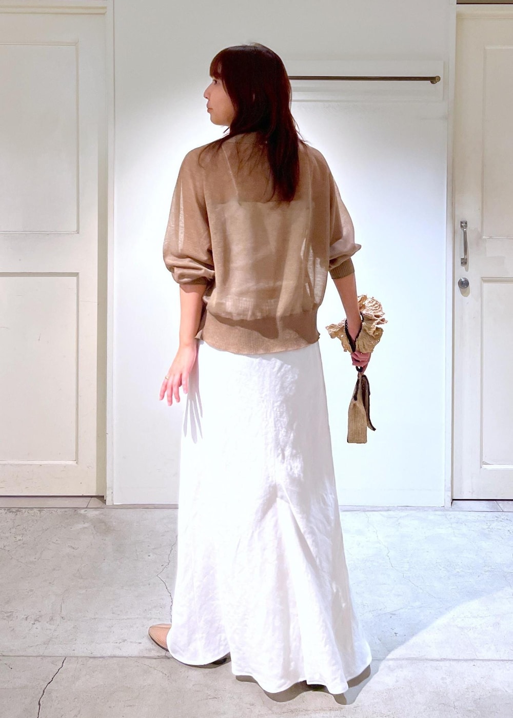 ベージュ系のパンプス、ホワイト系のスカート、ホワイト系のキャミソールを着用したレディースの春コーディネートの4枚目の写真