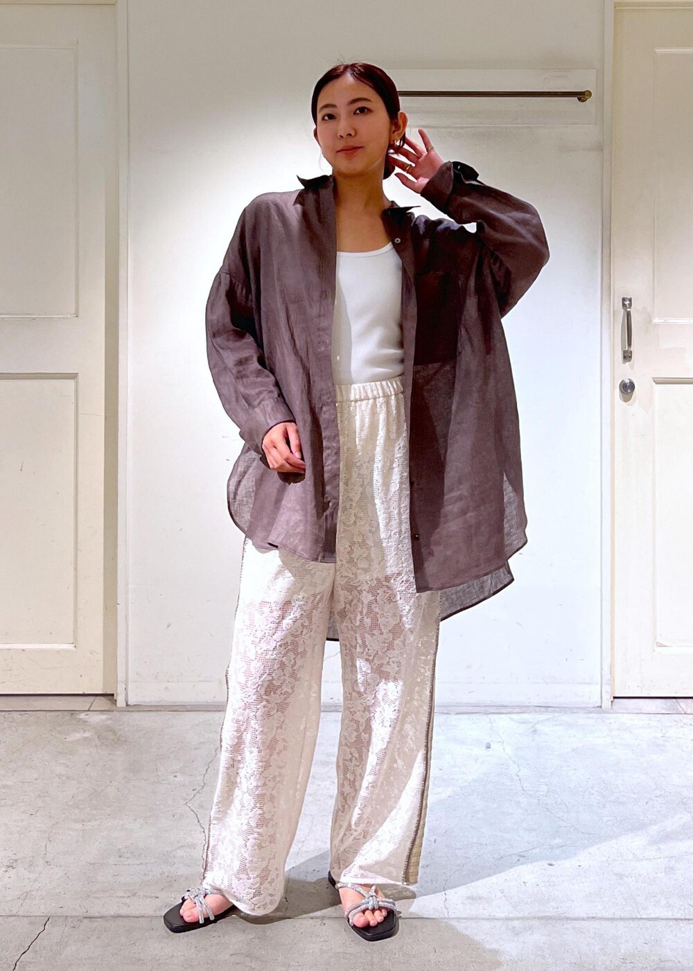 シルバー系のサンダル、ホワイト系のタンクトップ、イエロー系のキャミソールを着用したレディースの夏コーディネートの10枚目の写真