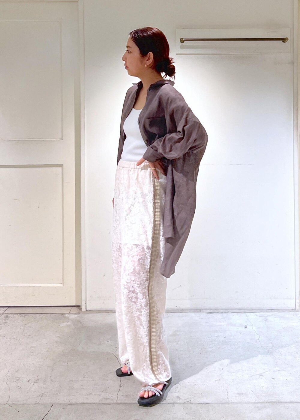 シルバー系のサンダル、ホワイト系のタンクトップ、イエロー系のキャミソールを着用したレディースの夏コーディネートの9枚目の写真