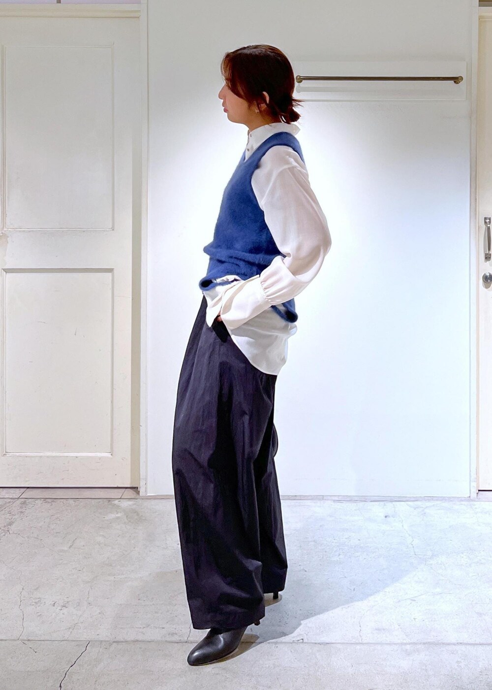 ブルー系のタンクトップ、ホワイト系のシャツ/ブラウス、ブラック系のブーツを着用したレディースの秋コーディネートの5枚目の写真