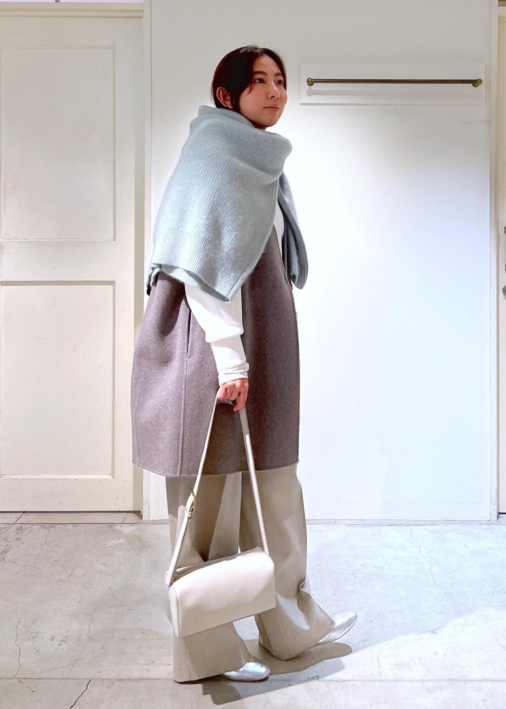 シルバー系のその他シューズ、グレー系のショルダーバッグ、グリーン系のカーディガン/ボレロを着用したレディースの冬コーディネートの2枚目の写真