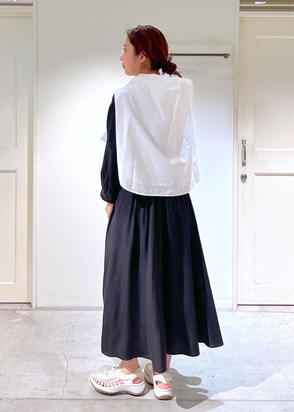 ホワイト系のサンダル、ブラック系のショルダーバッグ、ブラック系のワンピースを着用したレディースの春コーディネートの3枚目の写真