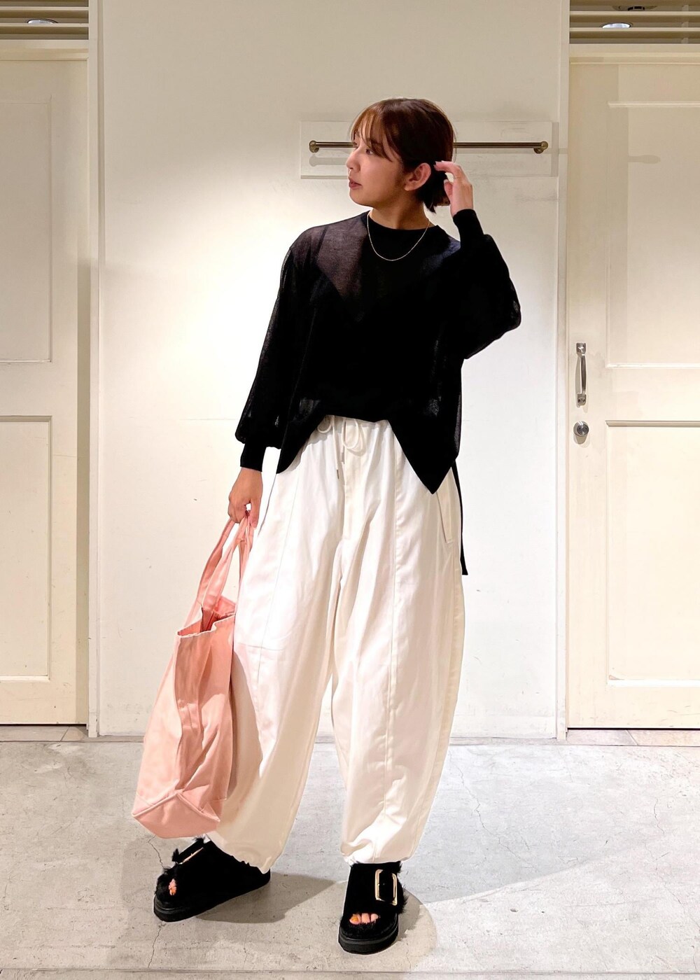 ホワイト系のカーゴパンツ、ブラック系のTシャツ/カットソー、ピンク系のトートバッグを着用したレディースの夏コーディネートの3枚目の写真