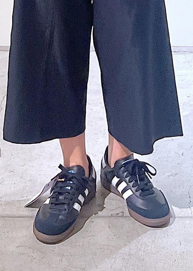 ブラック系のその他パンツ、ホワイト系のハンドバッグ、グリーン系のタンクトップを着用したレディースの夏コーディネートの7枚目の写真