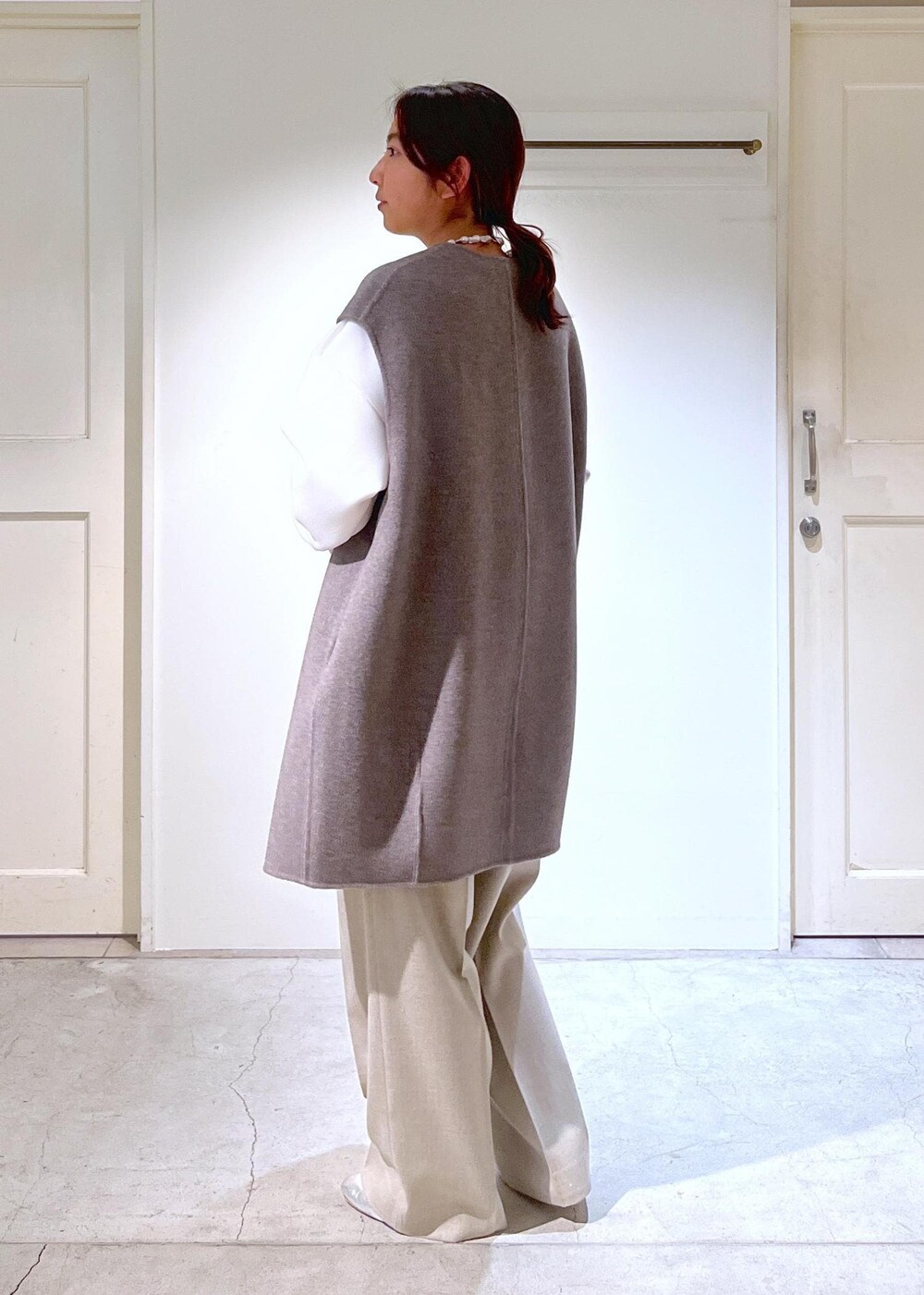 シルバー系のその他シューズ、グレー系のショルダーバッグ、グリーン系のカーディガン/ボレロを着用したレディースの冬コーディネートの3枚目の写真