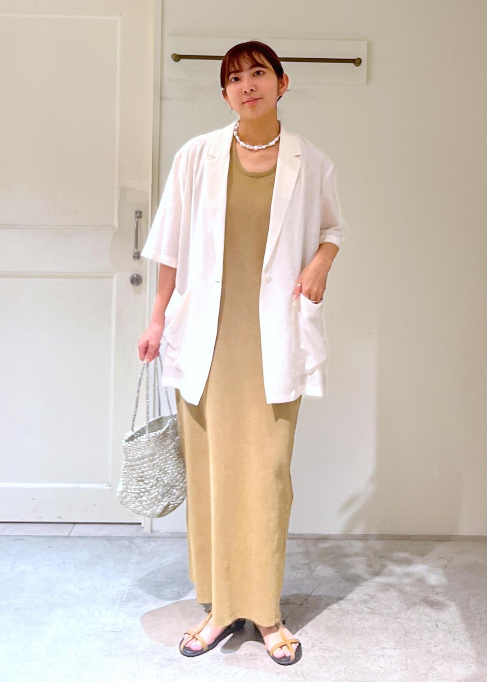 ベージュ系のサンダル、シルバー系のトートバッグ、ブラウン系のワンピースを着用したレディースの夏コーディネートの2枚目の写真