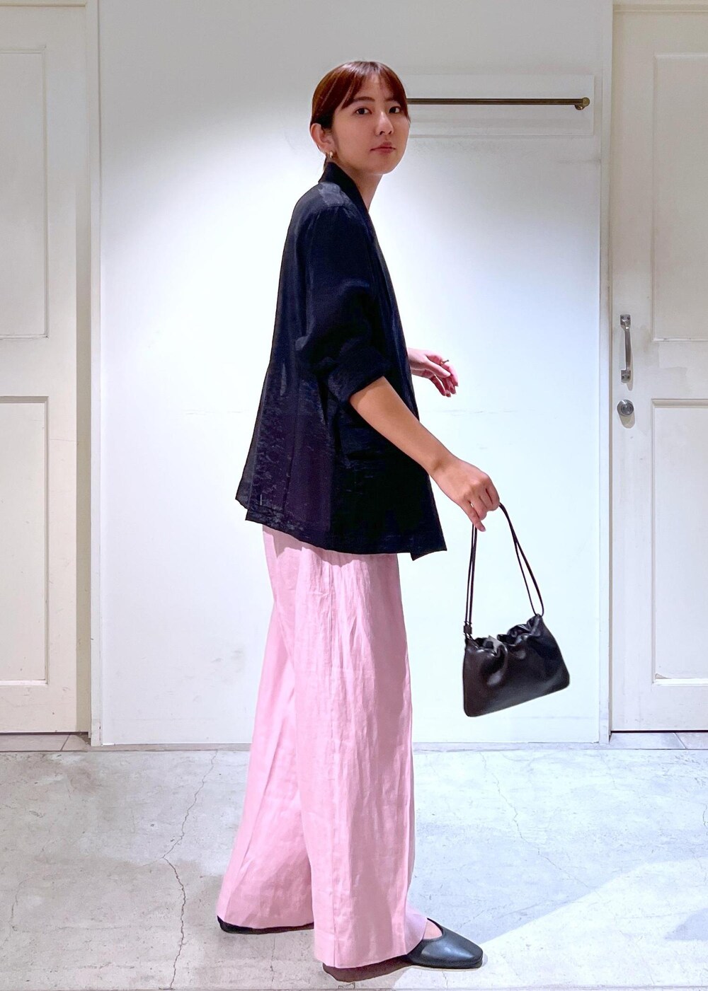 ピンク系のスラックス、ブラック系のタンクトップ、ブラック系のテーラードジャケットを着用したレディースの夏コーディネートの3枚目の写真