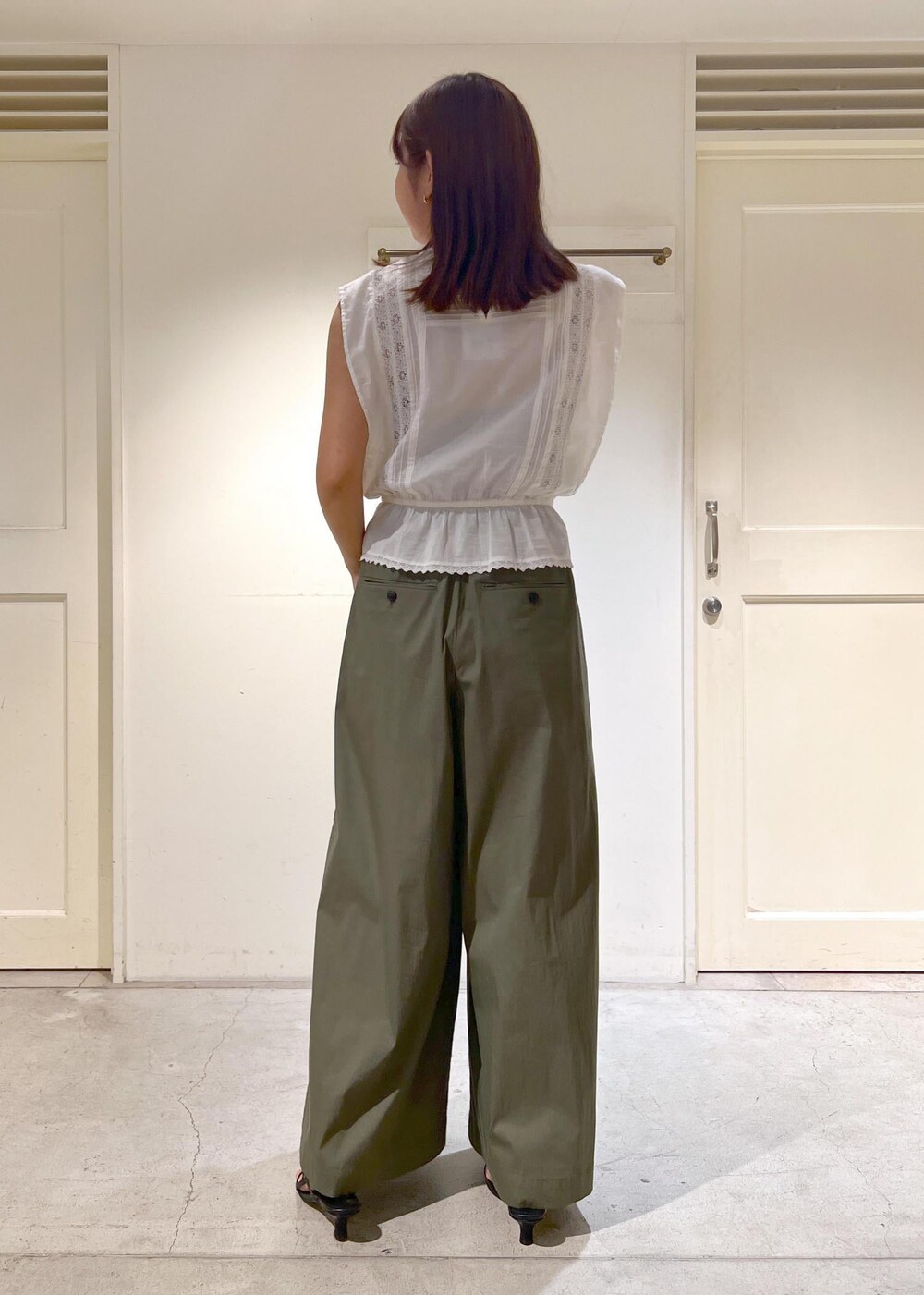 ブラック系のサンダル、グリーン系のその他パンツ、ホワイト系のシャツ/ブラウスを着用したレディースの夏コーディネートの3枚目の写真