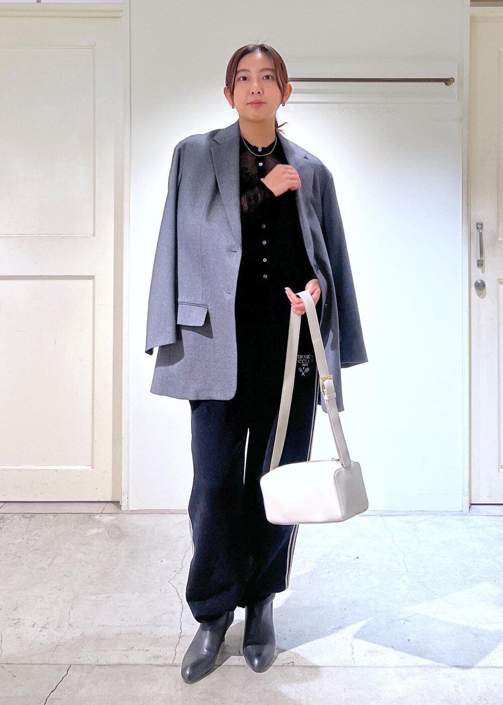 グレー系のテーラードジャケット、ブラック系のキャミソール、ブラック系のカーディガン/ボレロを着用したレディースの冬コーディネートの2枚目の写真