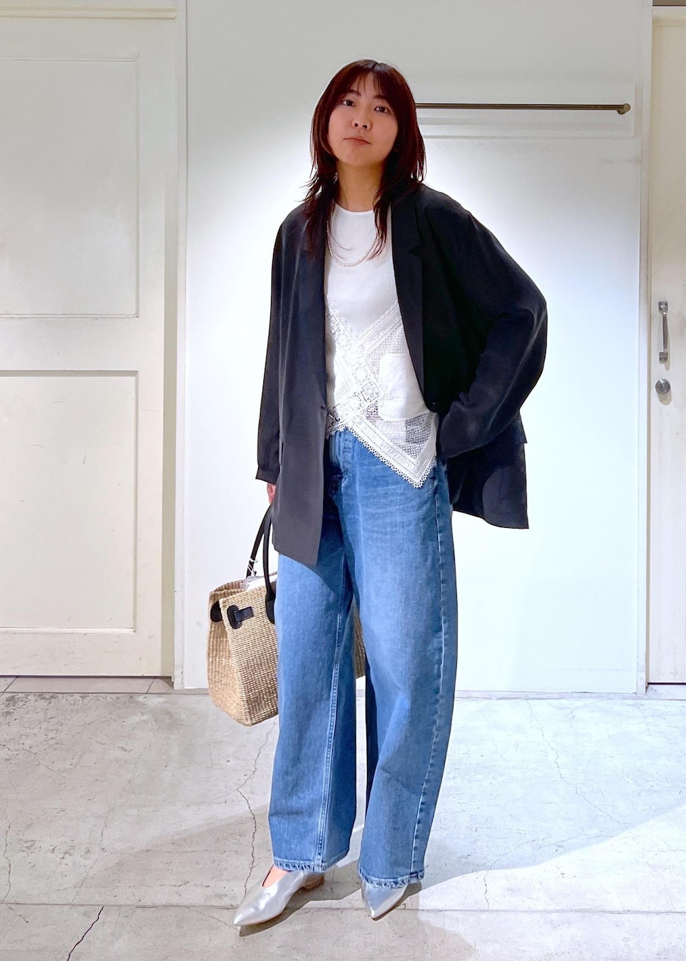ブルー系のデニムパンツ、ホワイト系のトートバッグ、ホワイト系のキャミソールを着用したレディースの春コーディネートの3枚目の写真