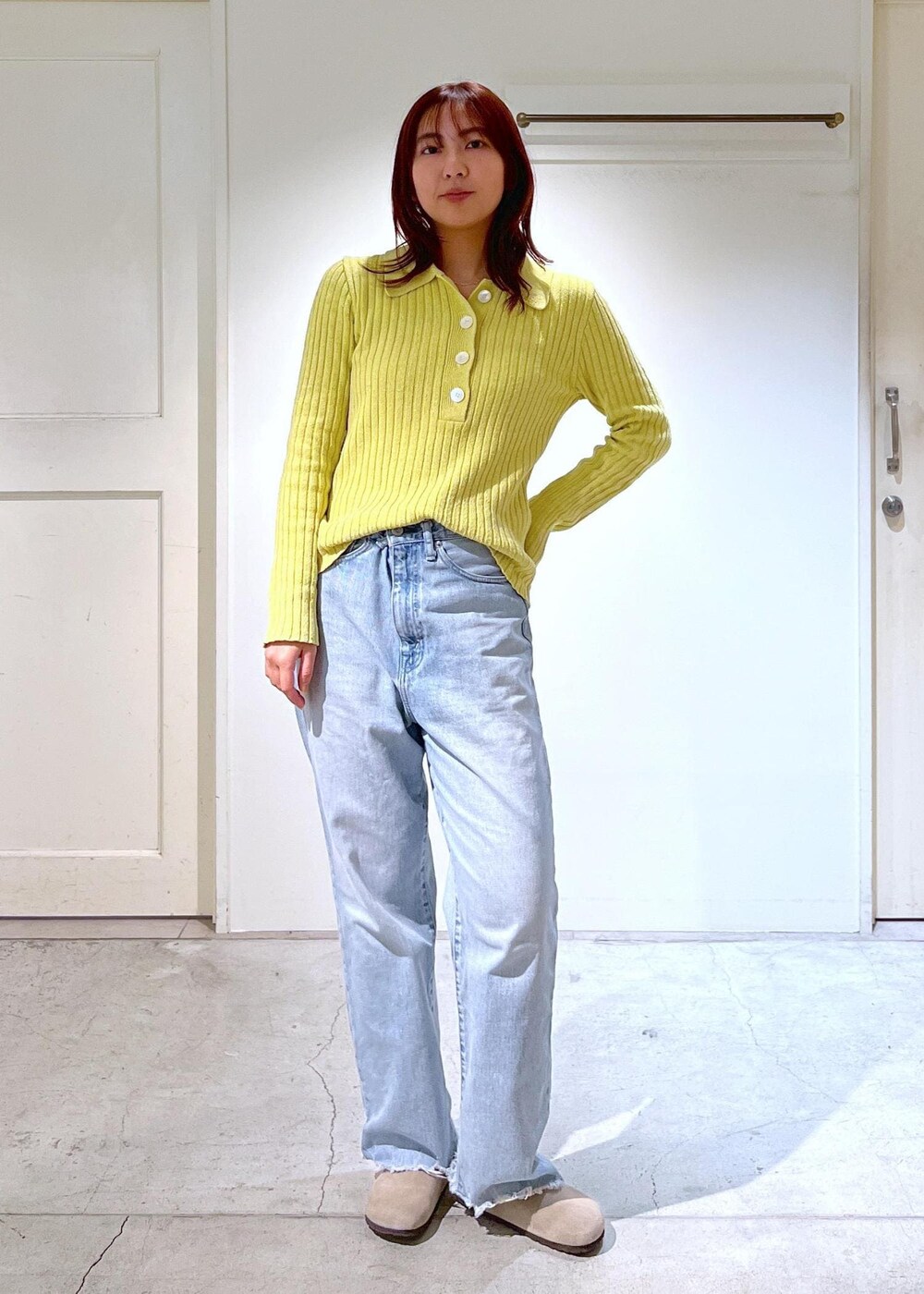 ベージュ系のボストンバッグ、イエロー系のニット/セーター、ブルー系のデニムパンツを着用したレディースの冬コーディネートの5枚目の写真