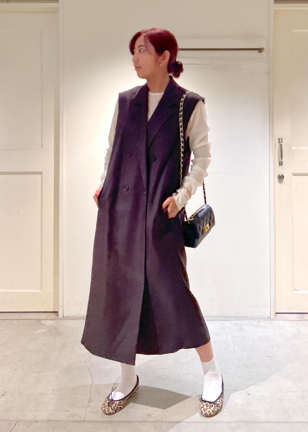 ブラック系のショルダーバッグ、ブラウン系のジャンパースカート、ブラウン系のバレエシューズを着用したレディースの秋コーディネートの2枚目の写真