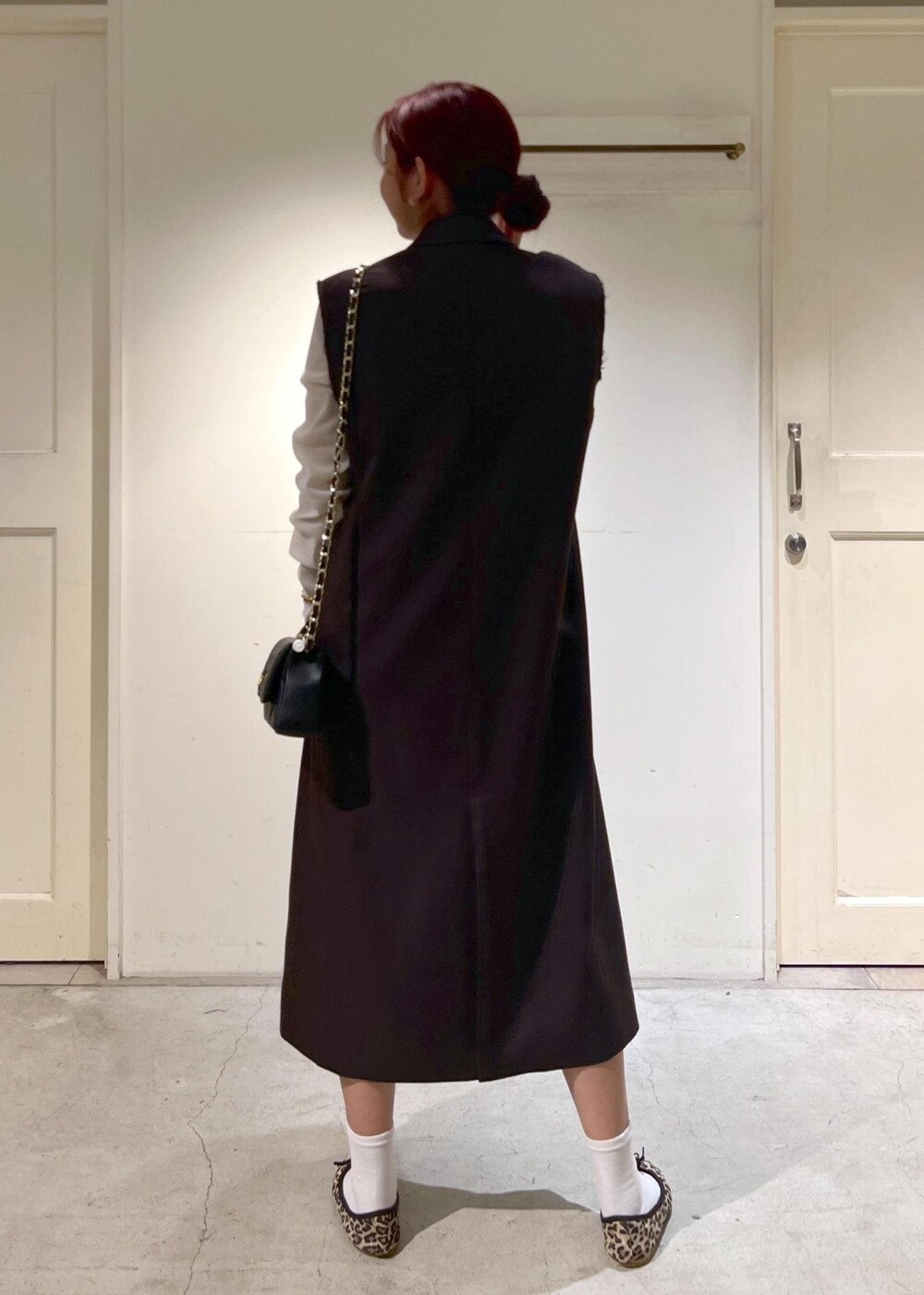 ブラック系のショルダーバッグ、ブラウン系のジャンパースカート、ブラウン系のバレエシューズを着用したレディースの秋コーディネートの4枚目の写真