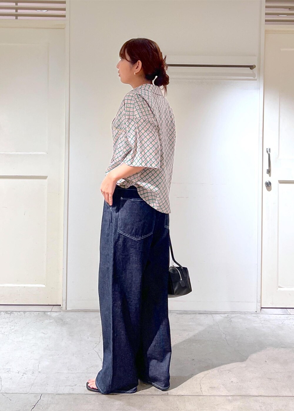 ブルー系のデニムパンツ、ブラック系のサンダル、グリーン系のシャツ/ブラウスを着用したレディースの夏コーディネートの3枚目の写真