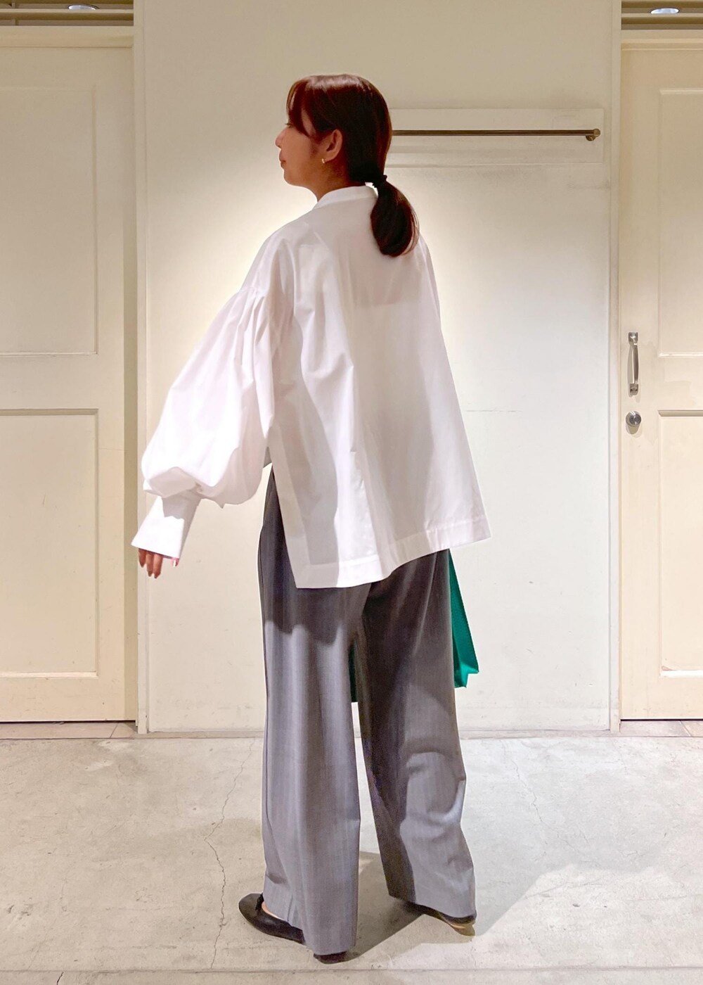 グレー系のスラックス、ホワイト系のシャツ/ブラウス、グリーン系のトートバッグを着用したレディースの夏コーディネートの3枚目の写真