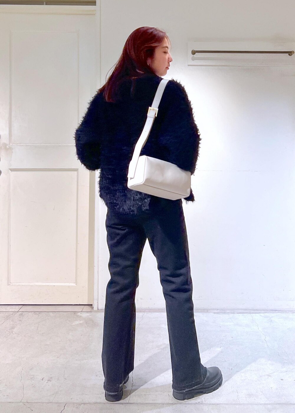 ブラック系のブーツ、ブラック系のTシャツ/カットソー、グレー系のデニムパンツを着用したレディースの秋コーディネートの7枚目の写真