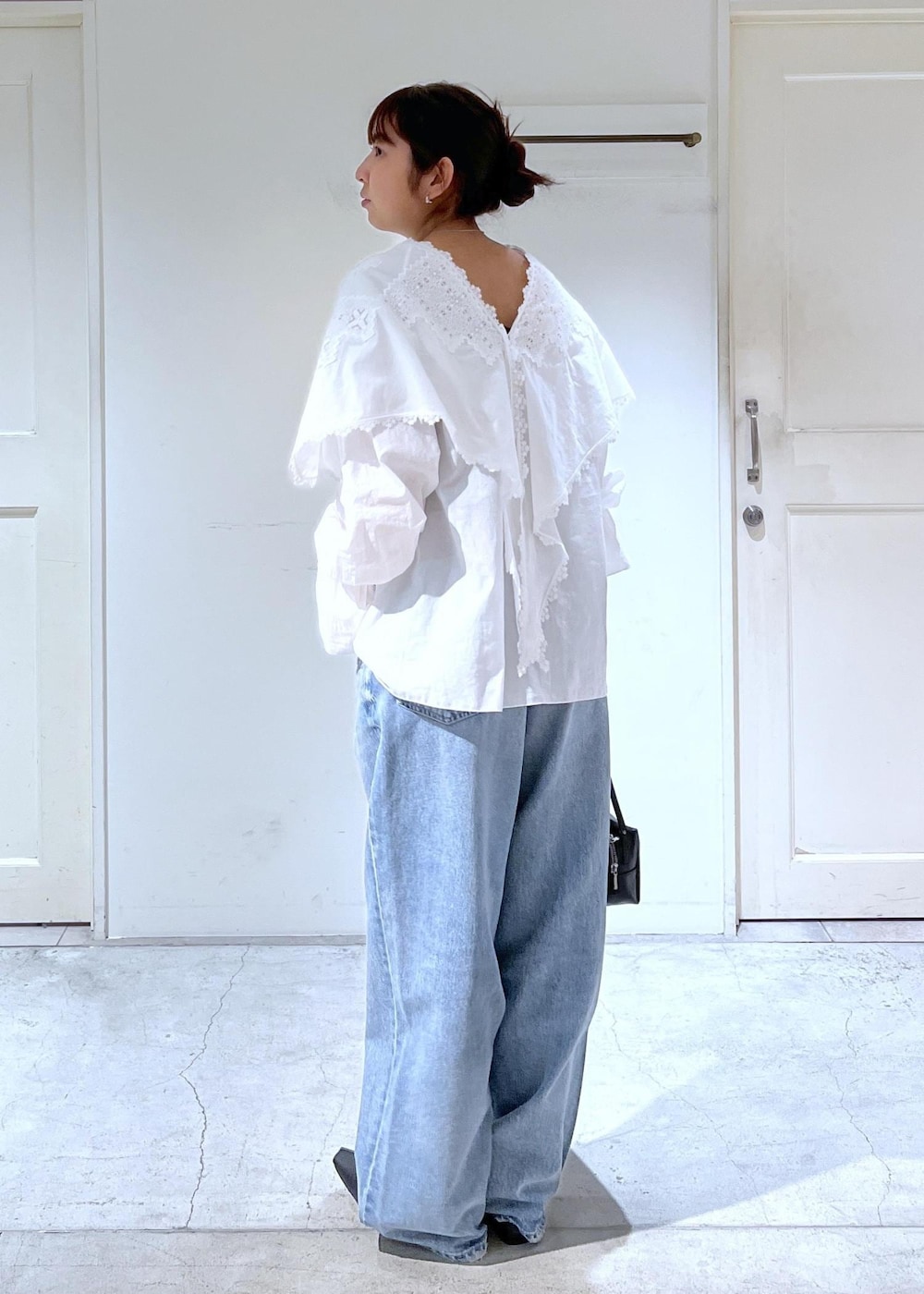 ブルー系のデニムパンツ、ブラック系のショルダーバッグ、ブラック系のその他シューズを着用したレディースの冬コーディネートの3枚目の写真