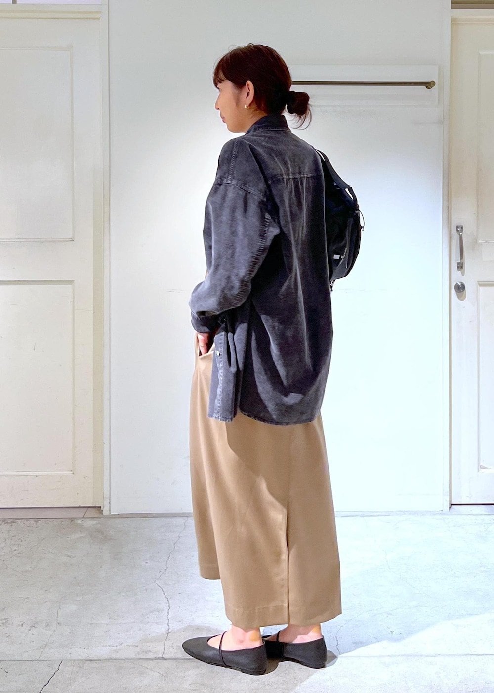 ブラック系のパンプス、グレー系のシャツ/ブラウス、ベージュ系のジャンパースカートを着用したレディースの秋コーディネートの5枚目の写真