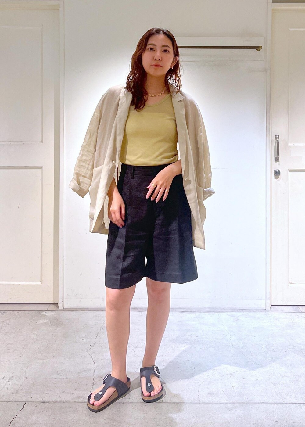 ブラック系のショルダーバッグ、ベージュ系のテーラードジャケット、ブラック系のその他パンツを着用したレディースの夏コーディネートの2枚目の写真