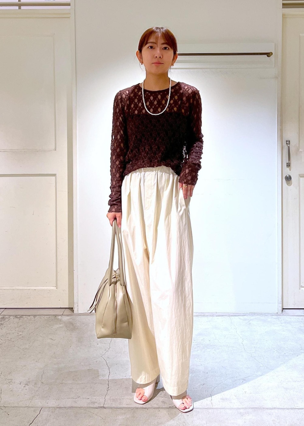 ベージュ系のボストンバッグ、グレー系のサンダル、ホワイト系のその他パンツを着用したレディースの夏コーディネートの2枚目の写真