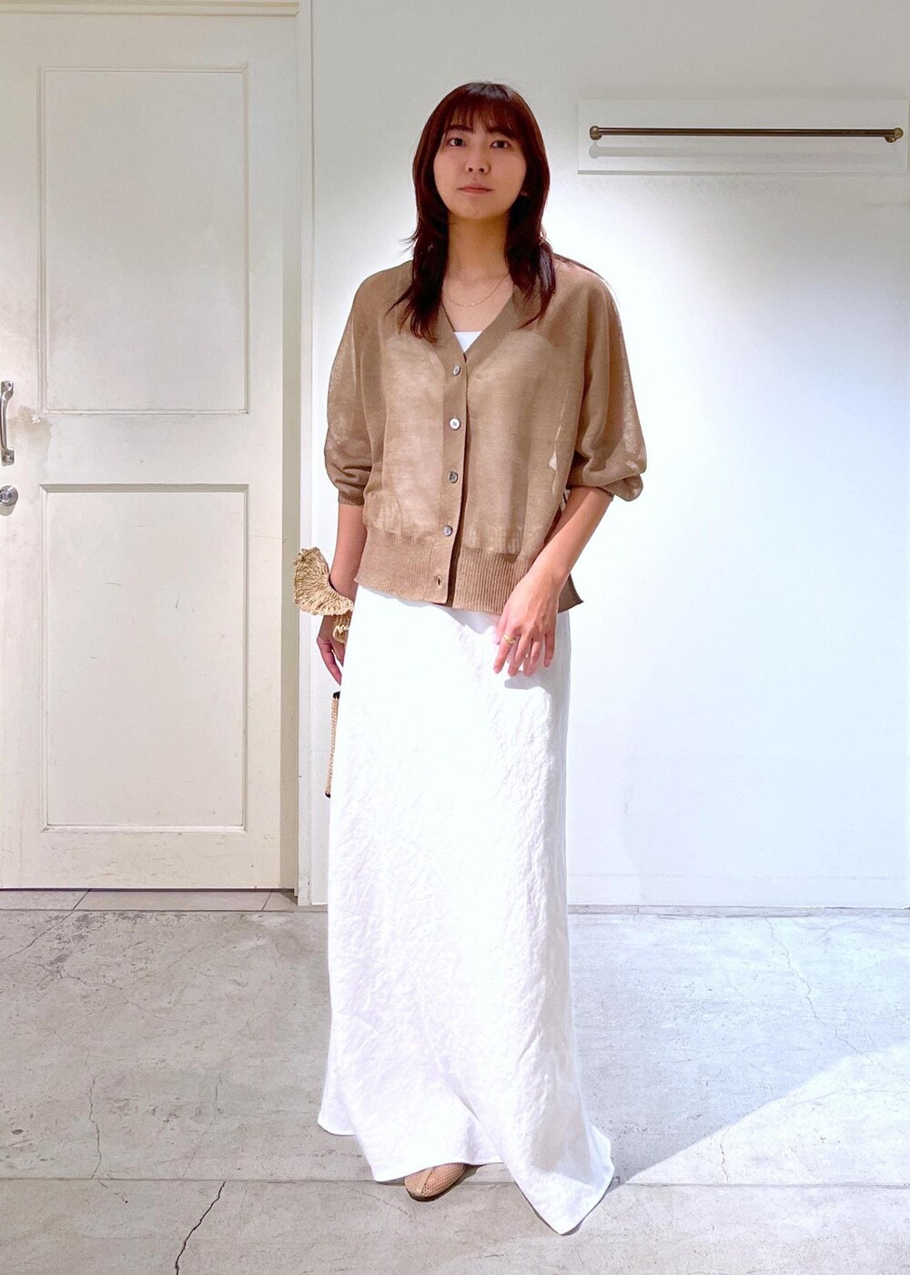 ベージュ系のパンプス、ホワイト系のスカート、ホワイト系のキャミソールを着用したレディースの春コーディネートの2枚目の写真